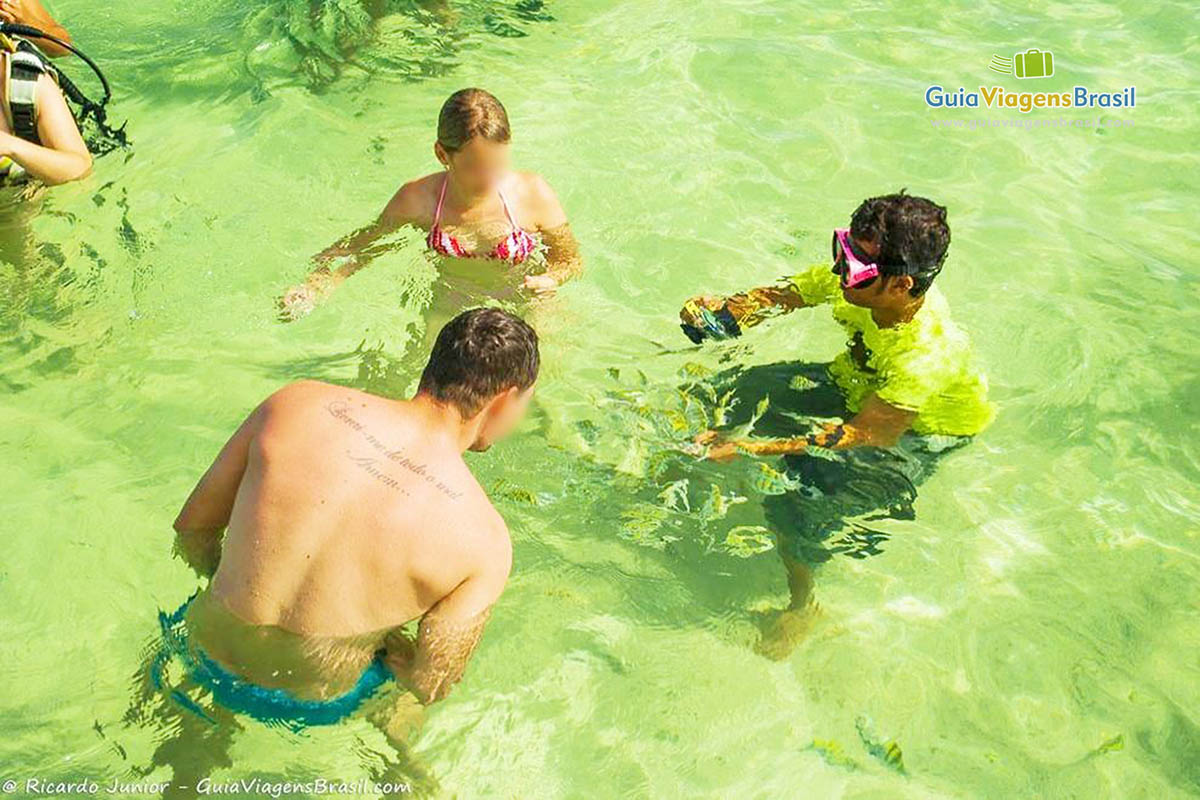 Imagem de turistas tirando fotos do peixes na piscina natural de Paripueira.