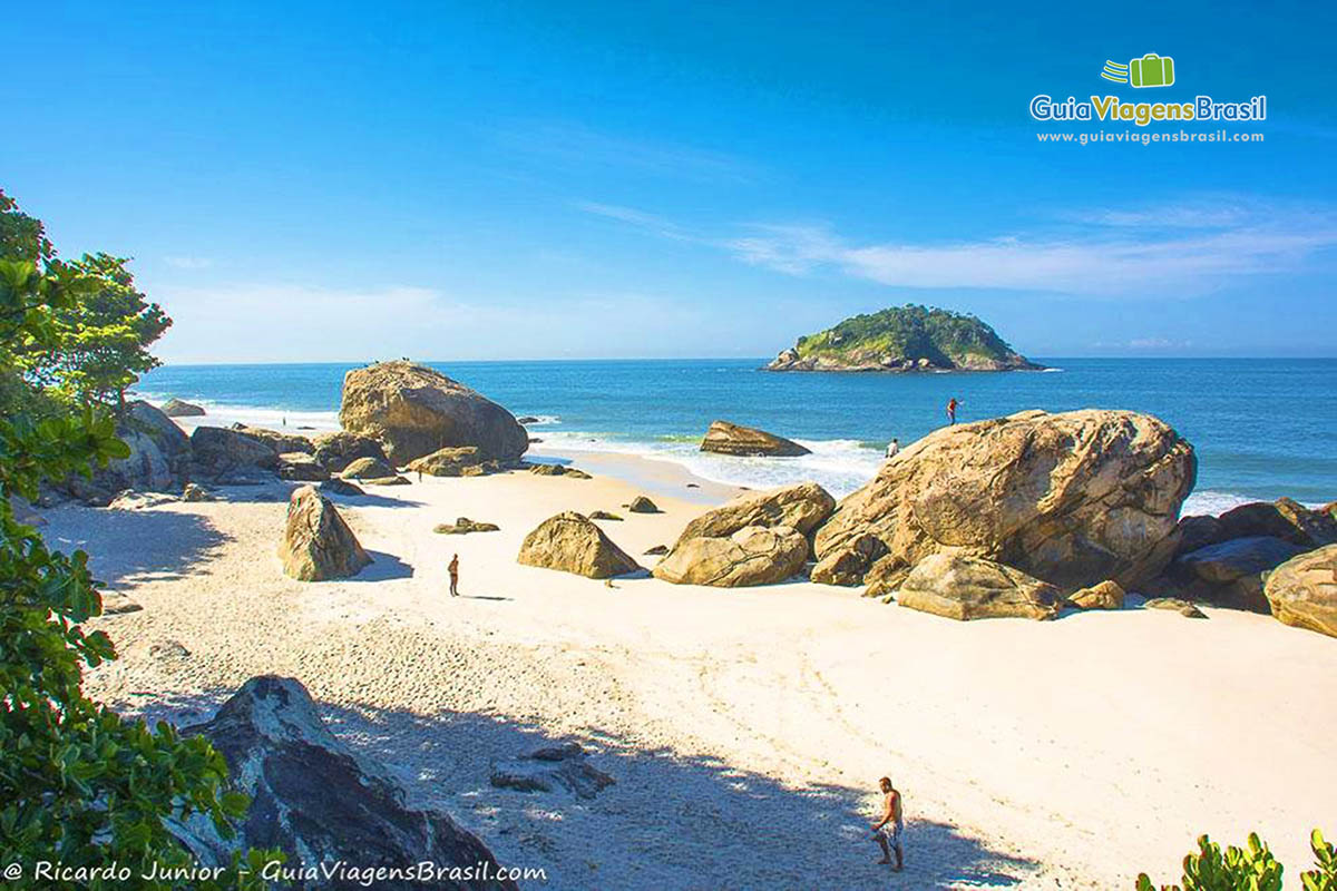 Imagem de pessoas nas areias da Praia Abrico, no Rio de Janeiro.