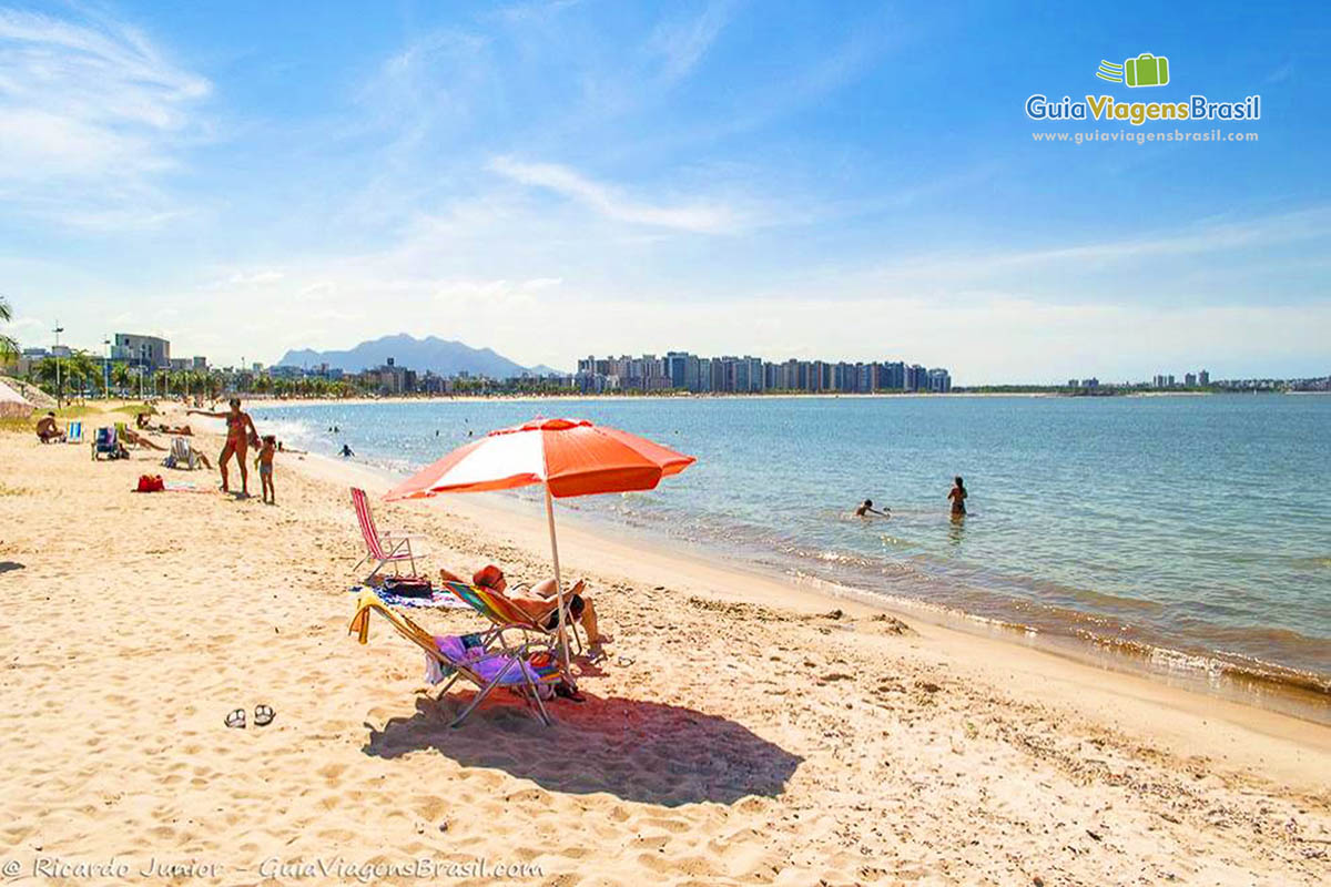 Imagem de pessoas nas areias, no mar e ao fundo os prédios da Praia Cambori.