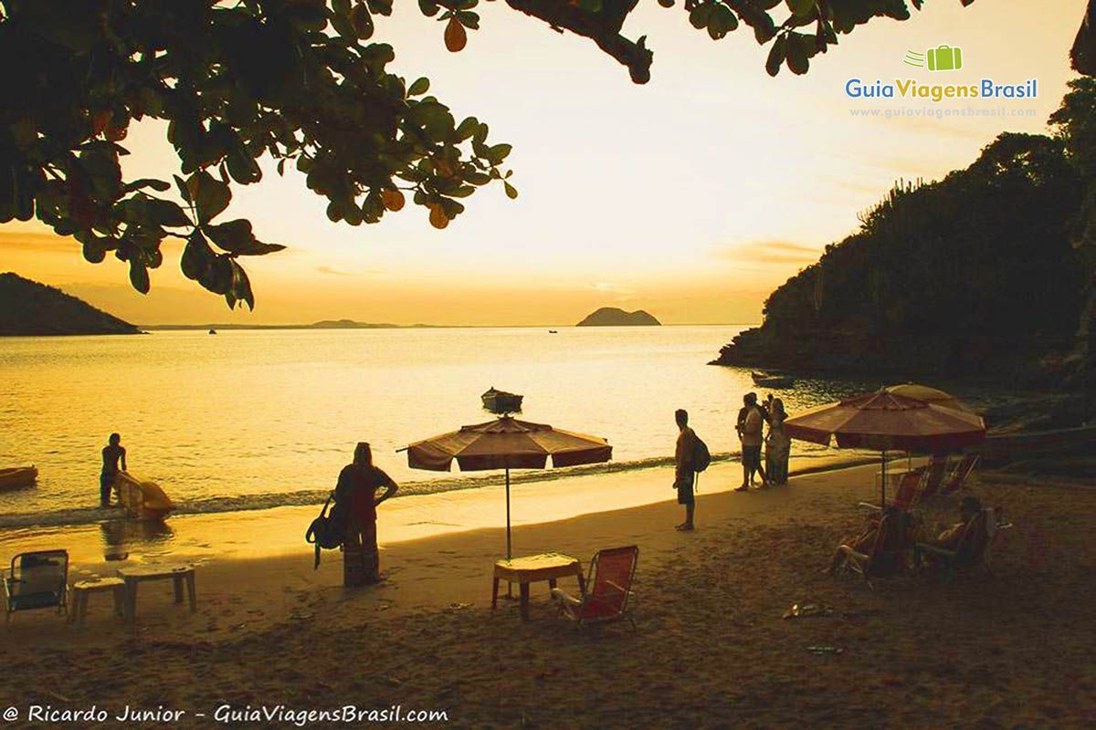 Imagem de pessoas na linda tarde da praia de Búzios.