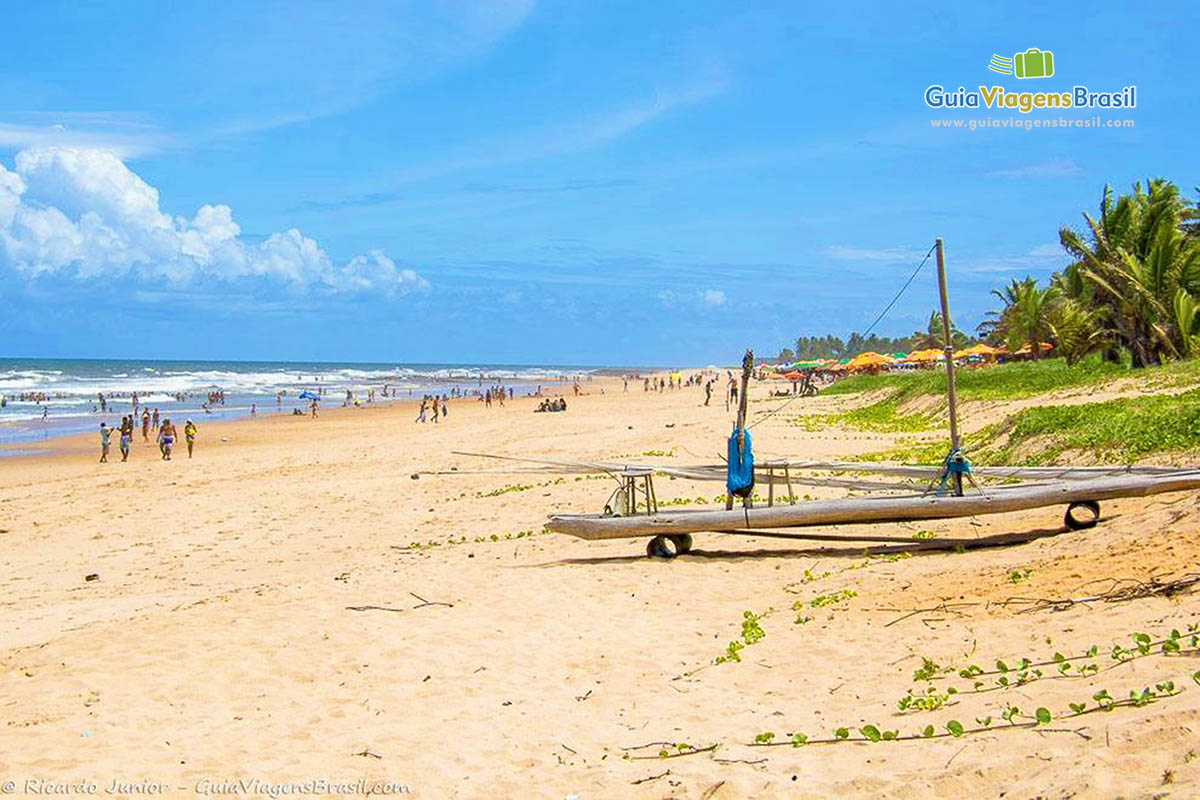 Imagem de turistas nas areias da Praia de Imbassaí.