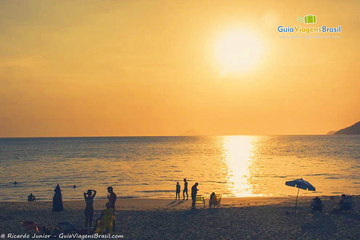 Imagem de pessoas curtindo o por do sol encantador em São Sebastião.