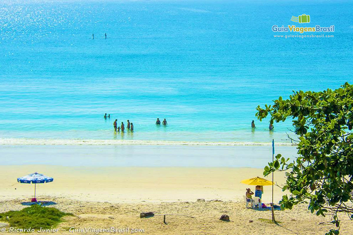 Imagem de pessoas aproveitando o mar.