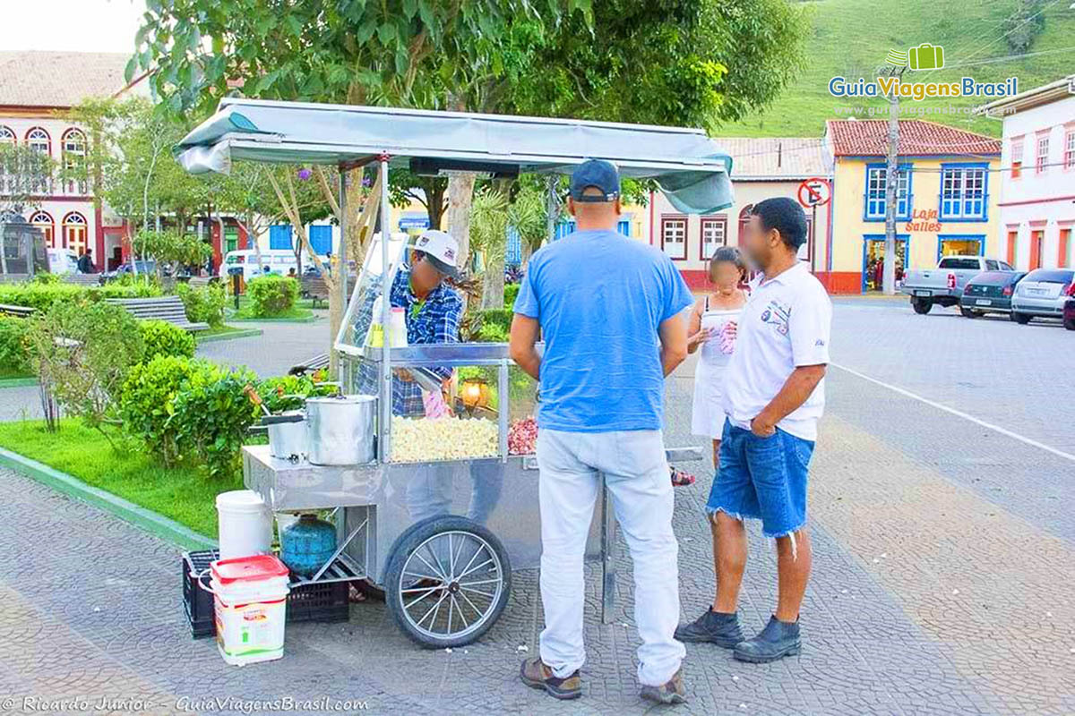 Imagem de carrinho de pipoca na praça da cidade.