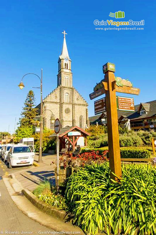 Imagem de uma placa indicando nome da rua e ao fundo a bela igreja.