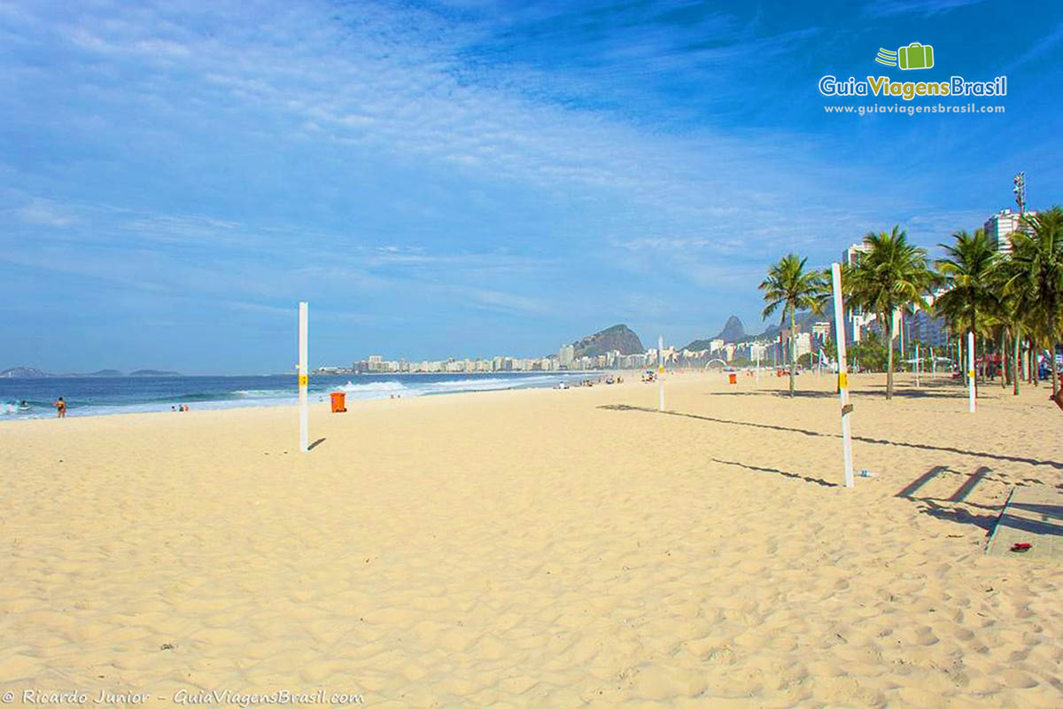 Imagem de madeiras na areia da praia para se colocar as redes e jogar futevôlei.