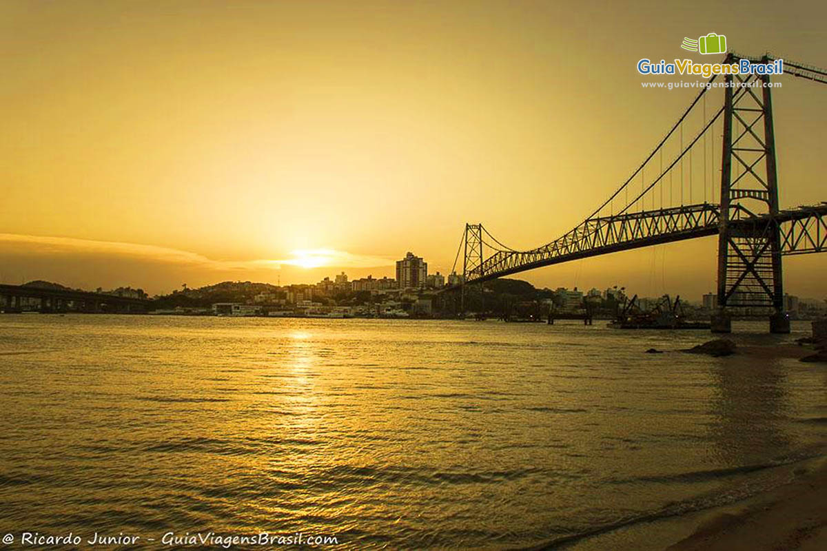 Imagem lindo por do sol ao fundo da Ponte Hercílio Luz.