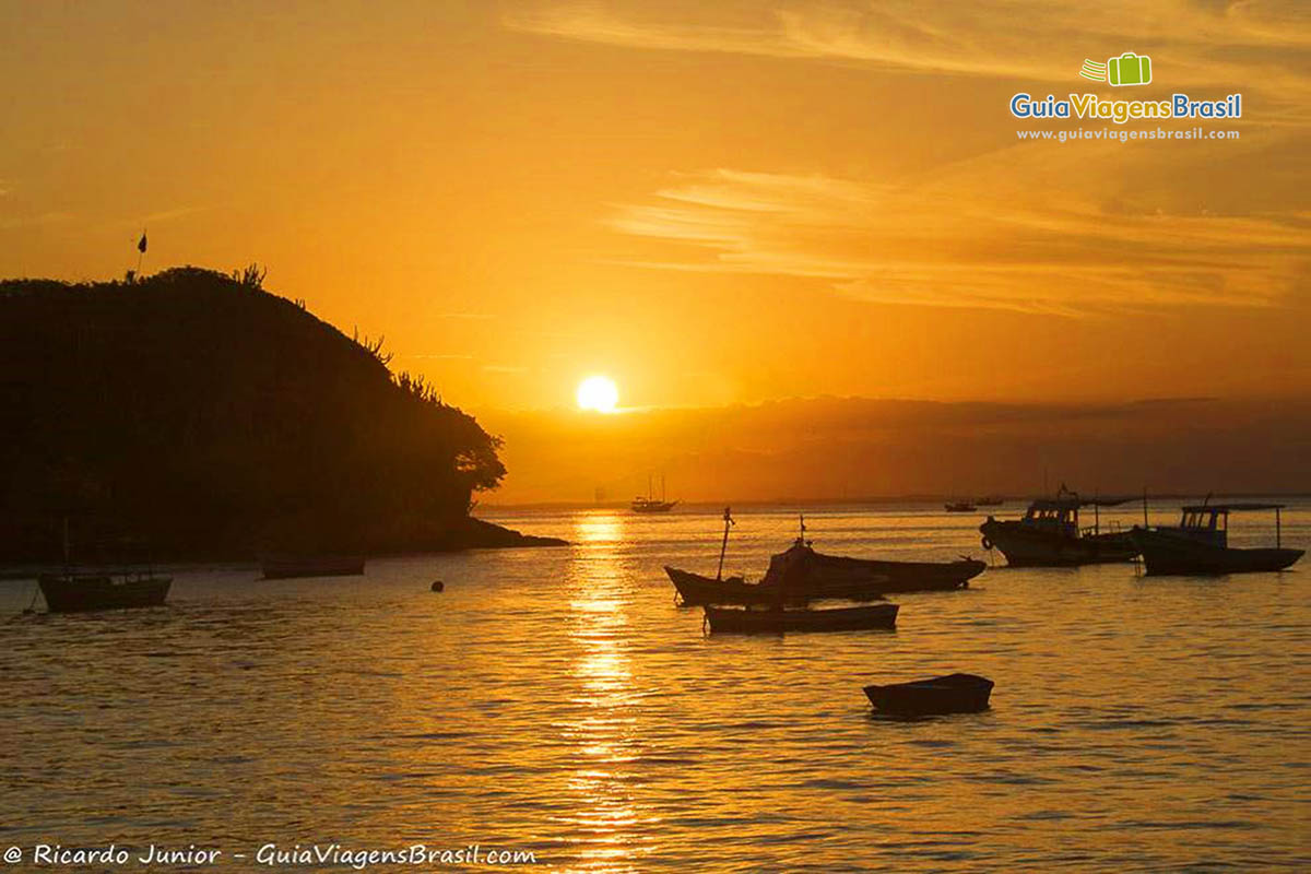Imagem do mar e da Ilha Cabloco com o sol de pondo no horizonte.