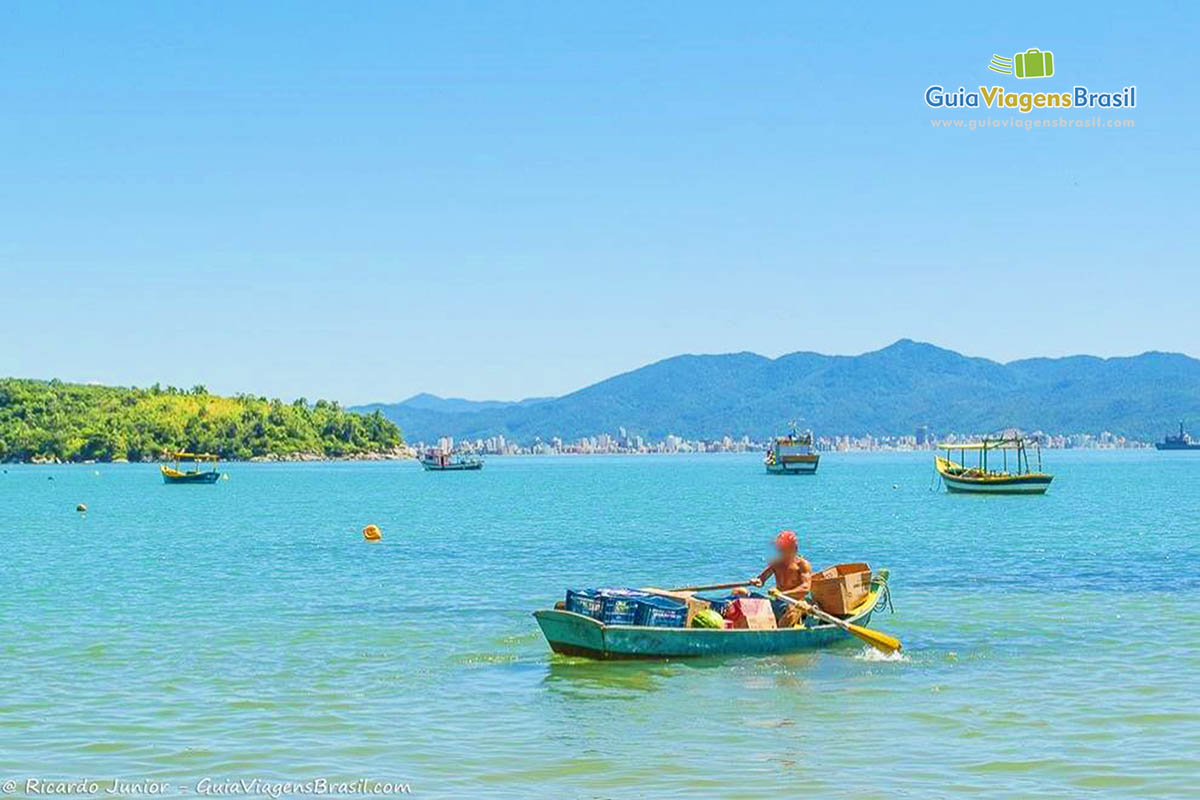 Imagem do pescador no mar com seu barco repleto de mantimentos.