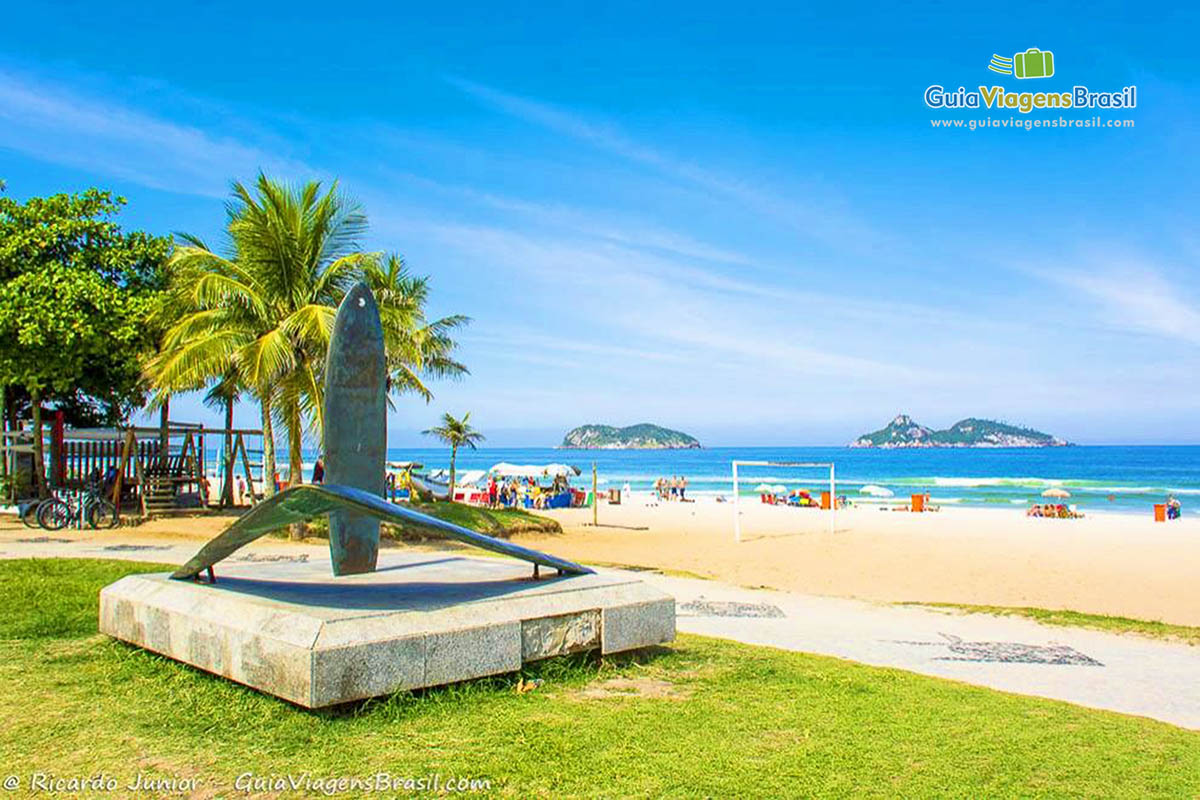 Imagem das pranchas de esculturas e ao fundo o lindo mar da Praia Barra da Tijuca.