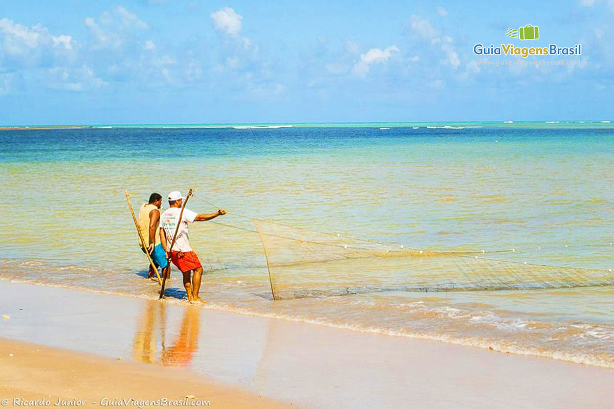 Imagem de dois amigos pescadores na beira da Praia Bitingui.