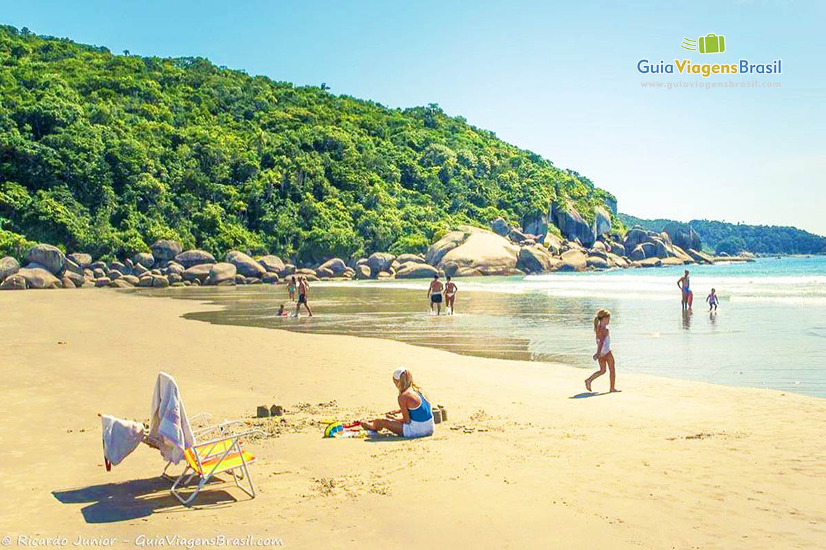 Imagem de crianças e adultos no canto da Praia Bombas.