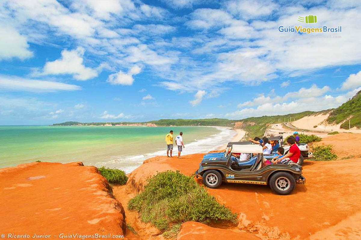 Imagem de turistas e jipe no mirante observando as belezas da Praia Cacimbinhas.