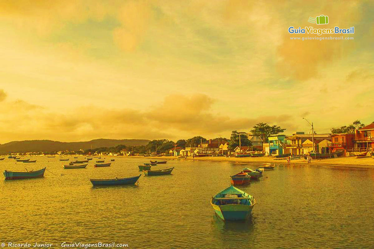 Imagem de barcos de pescador no mar e um belo entardecer.