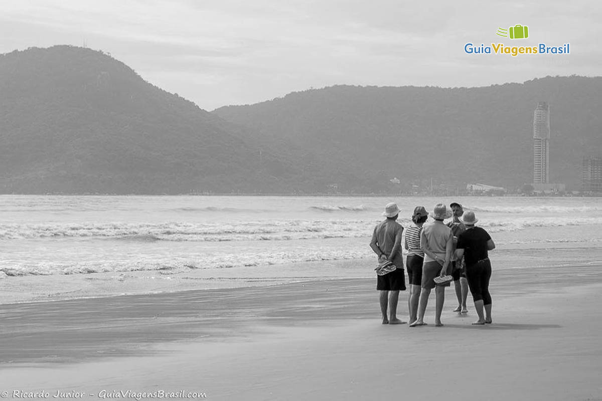 Imagem em preto e branco de senhoras e senhores nas areias da Praia Central.