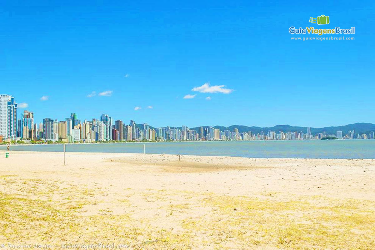 Imagem das areias do mar e os prédios da bela Praia Central.