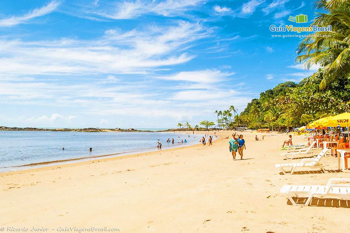 Imagem de turistas nas areias e na beira da praia em Itacaré.