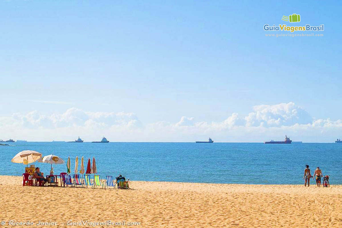 Imagem do mar azul com barcos ao fundo.