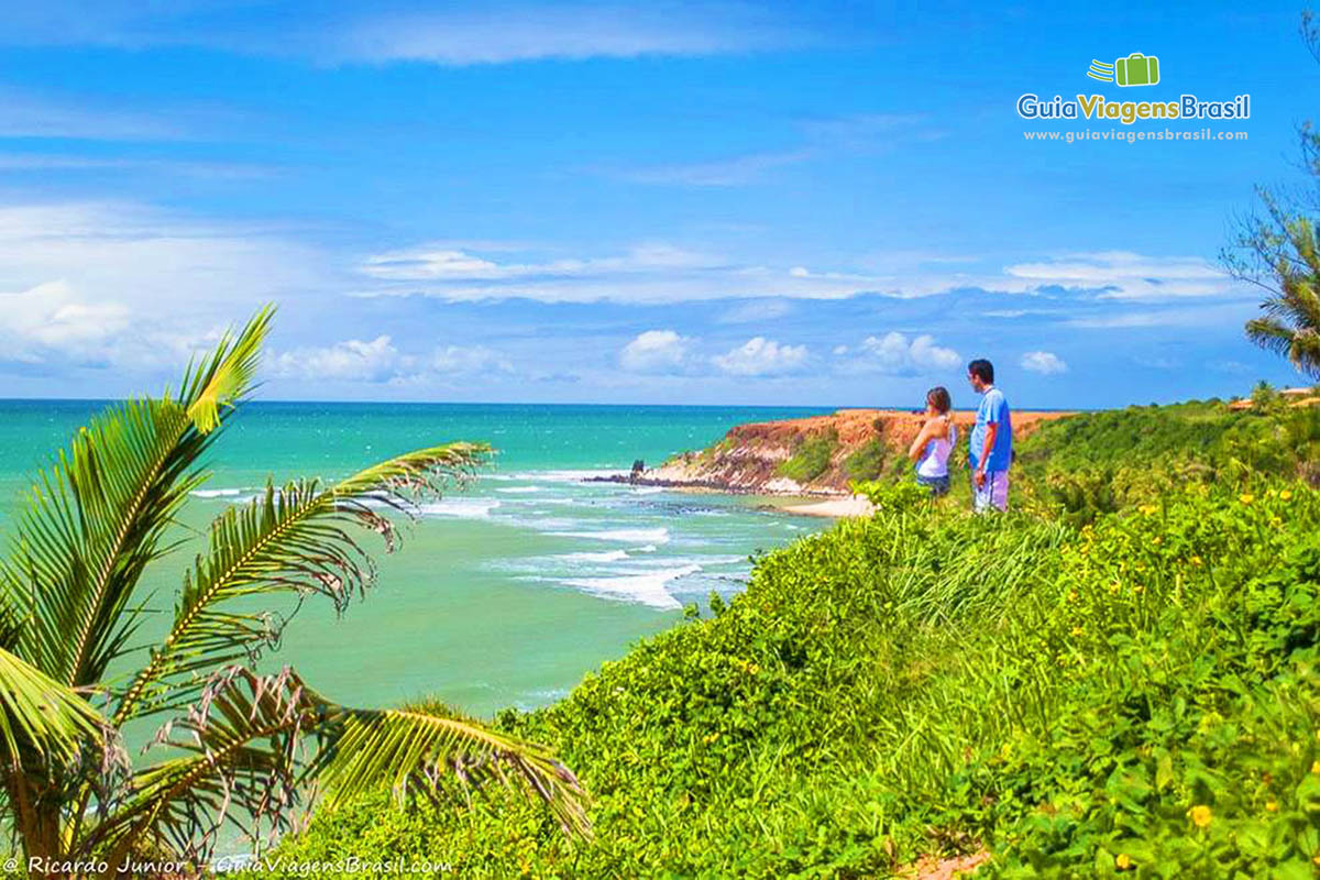 Imagem de um casal no mirante da bela Praia do Amor.