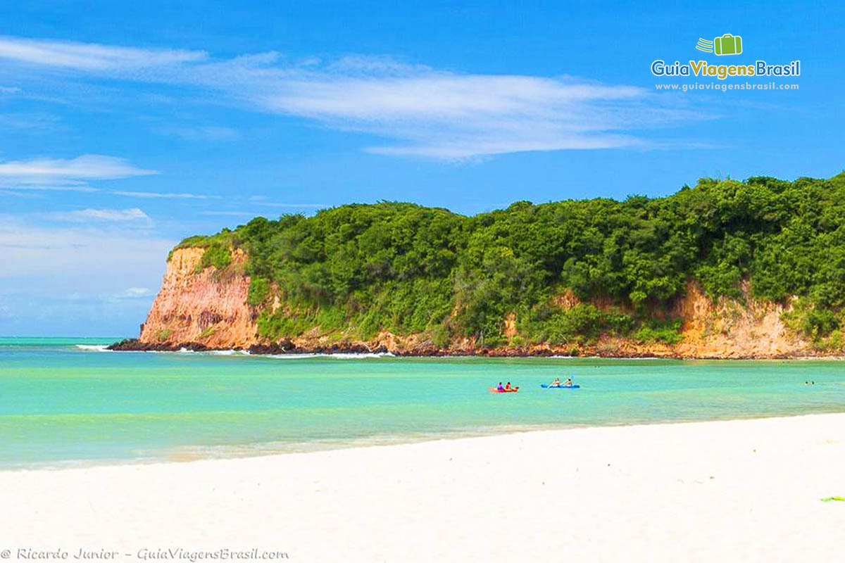 Imagem de caiaques nas águas azuis da Praia do Madeiro.