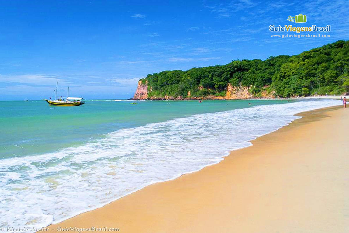 Imagem de um barco de passeio nas águas da Praia do Madeiro.