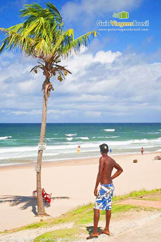 Imagem de um menino admirando o belo mar.