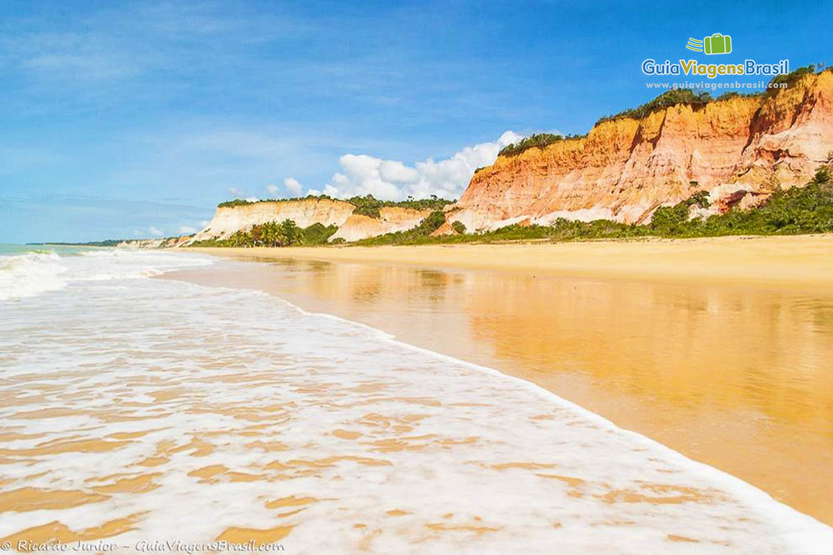 Imagem das espumas brancas na beira da praia.