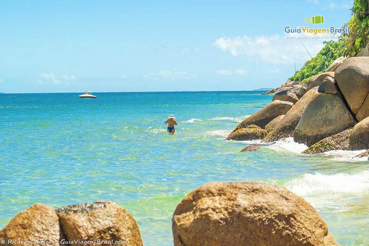 Imagem de uma senhora entrando no mar da linda Praia Lagoinha.