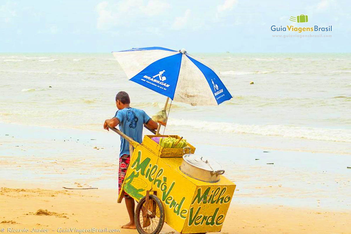 Imagem de vendedor ambulante nas areias da Praia Mundaí.