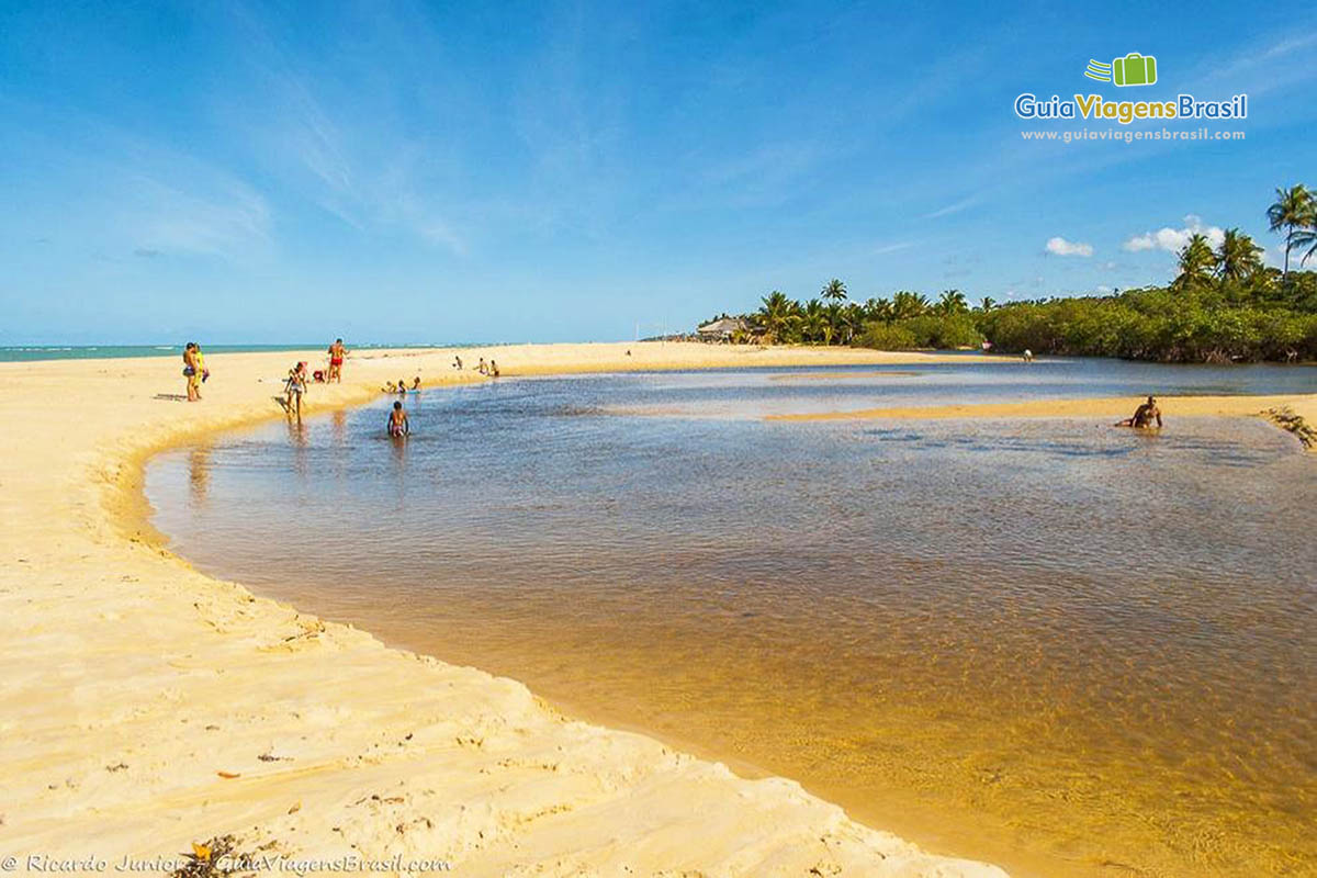 Imagem de pessoas aproveitando a piscina natural da Praia Nativos.