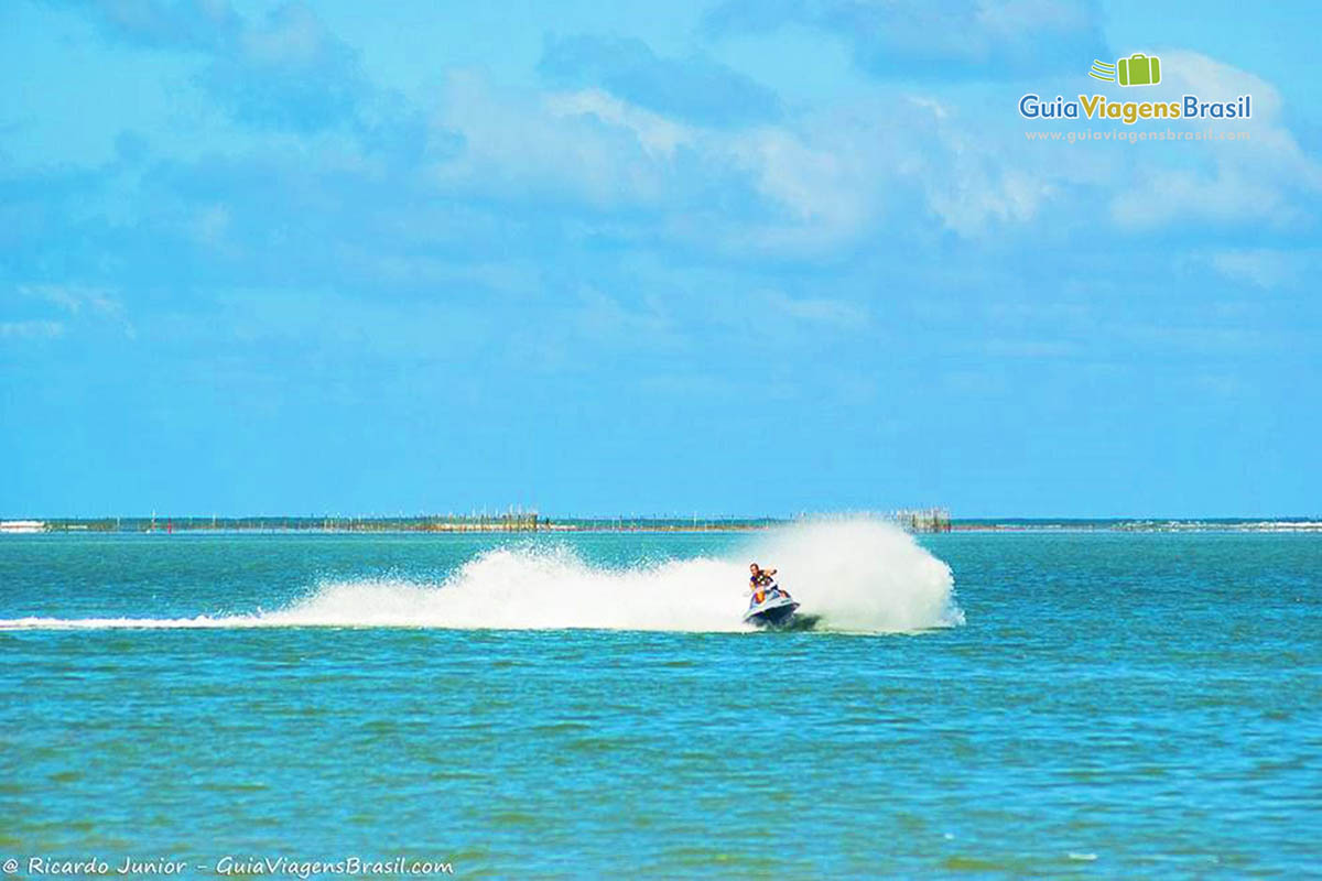 Imagem de uma pessoas andando de jet sky na bela praia.