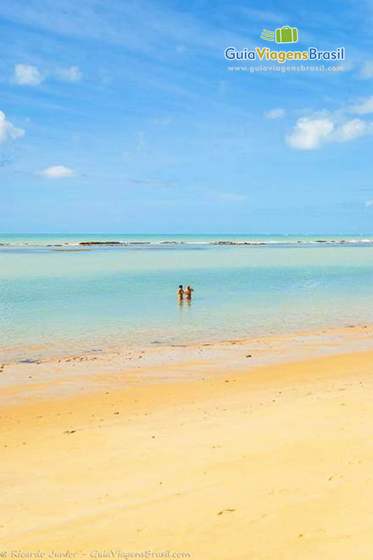 Imagem de casal nas águas cristalinas da Praia Parracho.