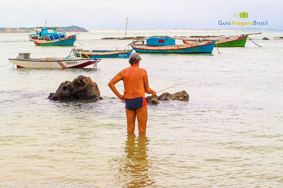 Imagem de um homem pescando nas águas da Praia Pipa.