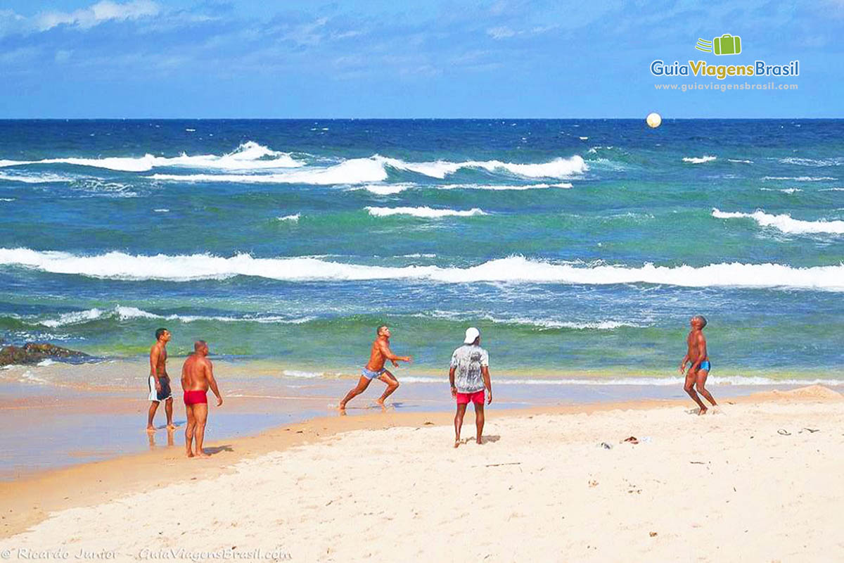 Imagem de amigos jogando bola nas areias da Praia de Pituba.