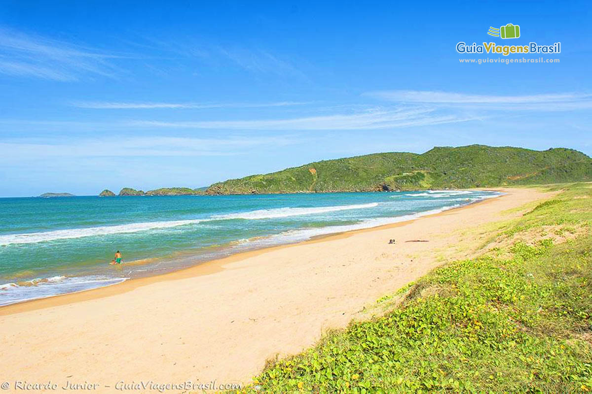 Imagem de um menino nas águas da Praia Tucuns.