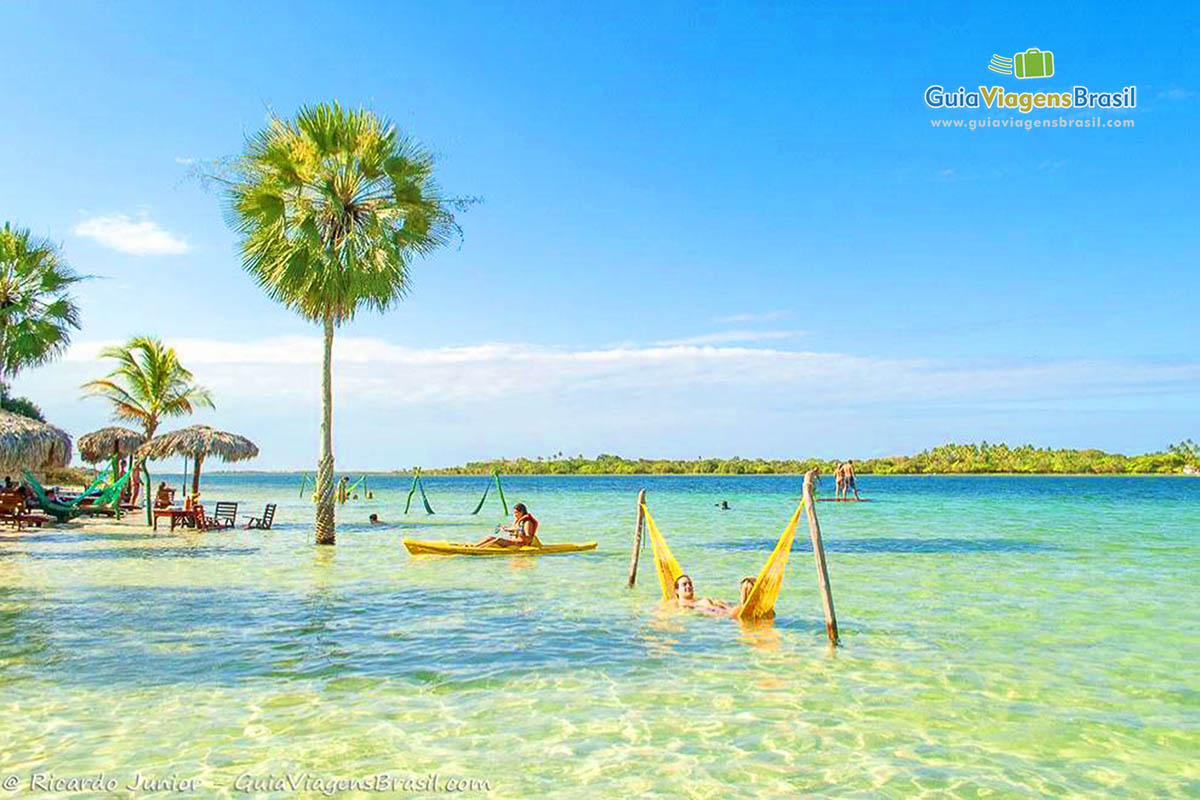 Imagem de pessoas na rede, no caique e no stand up paddle na Lagoa do Paraíso.