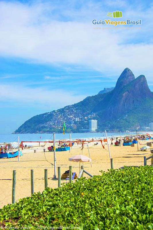 Imagem da praia e ao fundo belo morro do Rio de Janeiro.