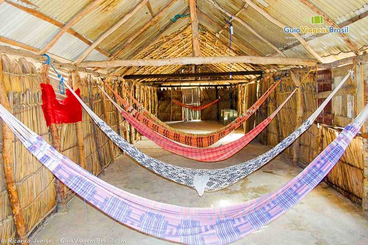Imagem de redes dentro de uma casa de sapê.