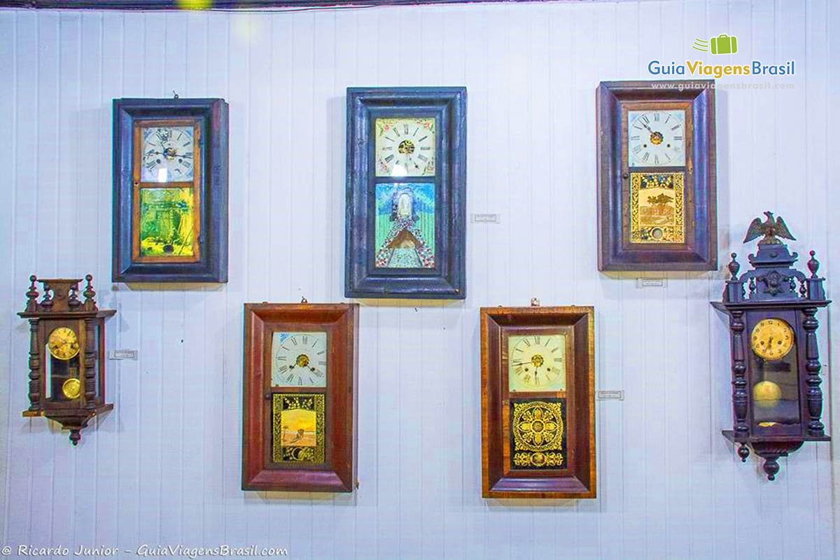 Imagem de vários modelos de relógios pendurados na parede.