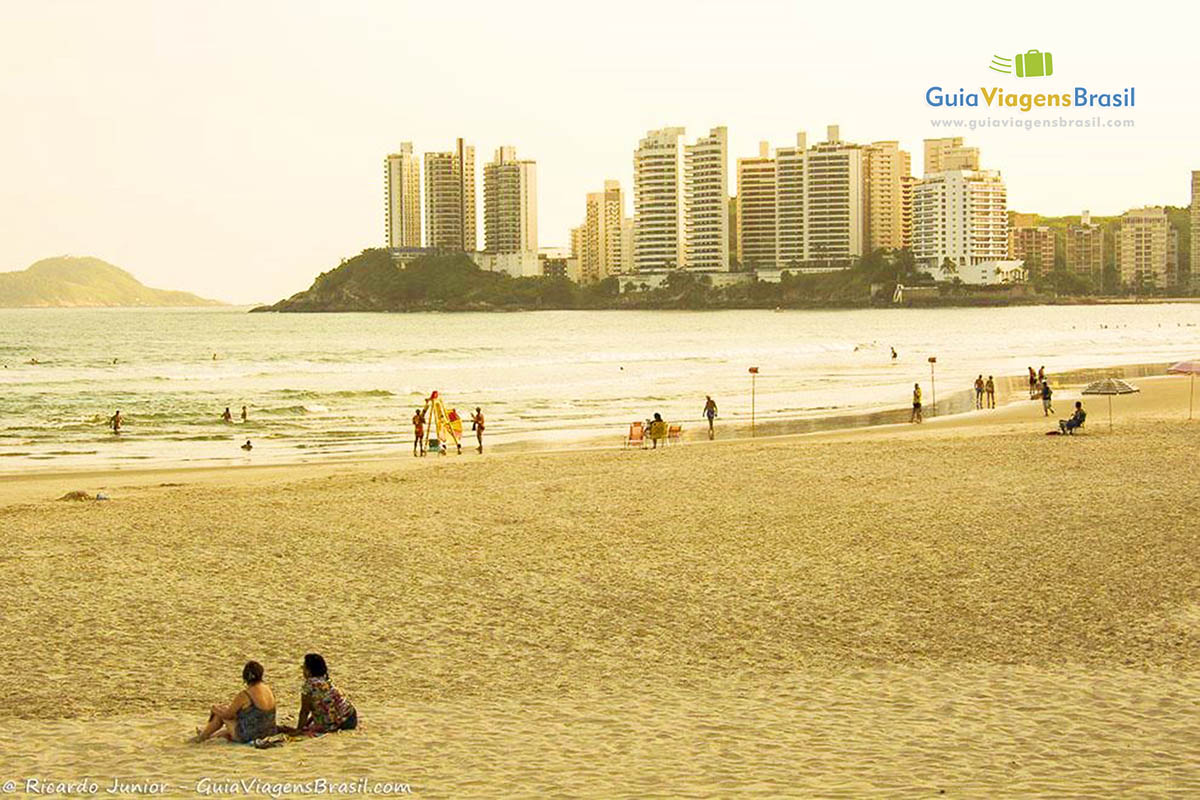 Imagem de turistas e salva vidas na areia da Praia Astúrias.