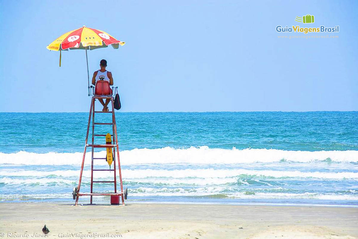 Imagem de um salva vidas guardo as pessoas no mar.