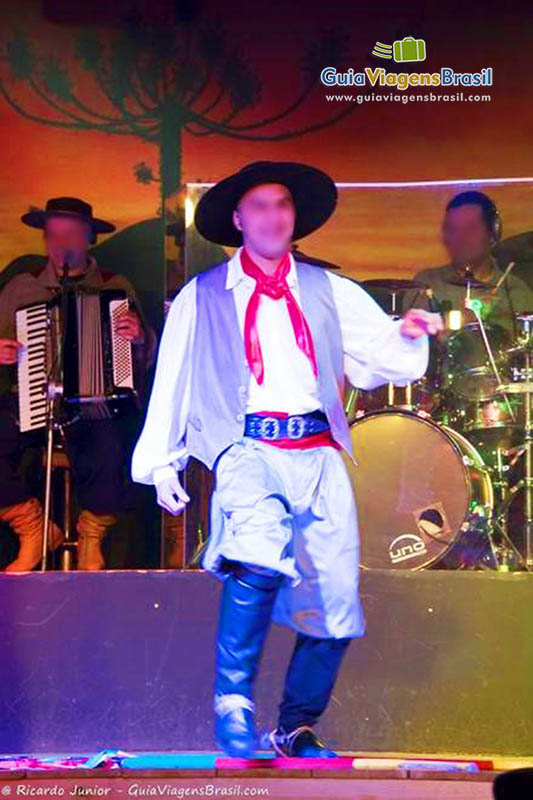 Imagem de um homem dançando com típica roupa gaúcha.