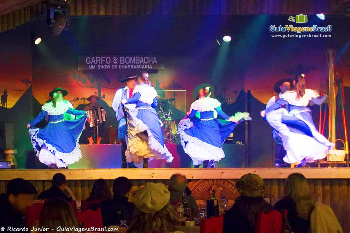 Imagem de casais no palco dançando lindamente.