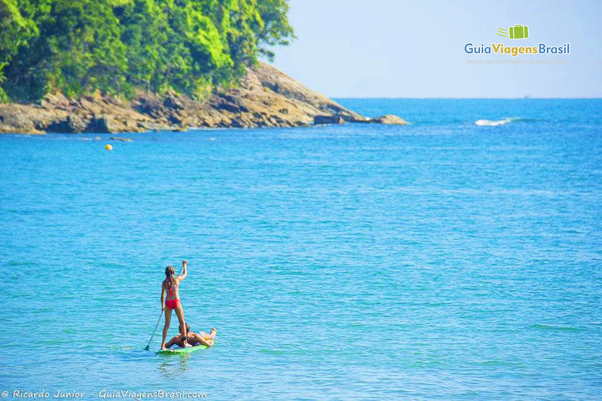 Imagem de uma pessoas fazendo stand up paddle.