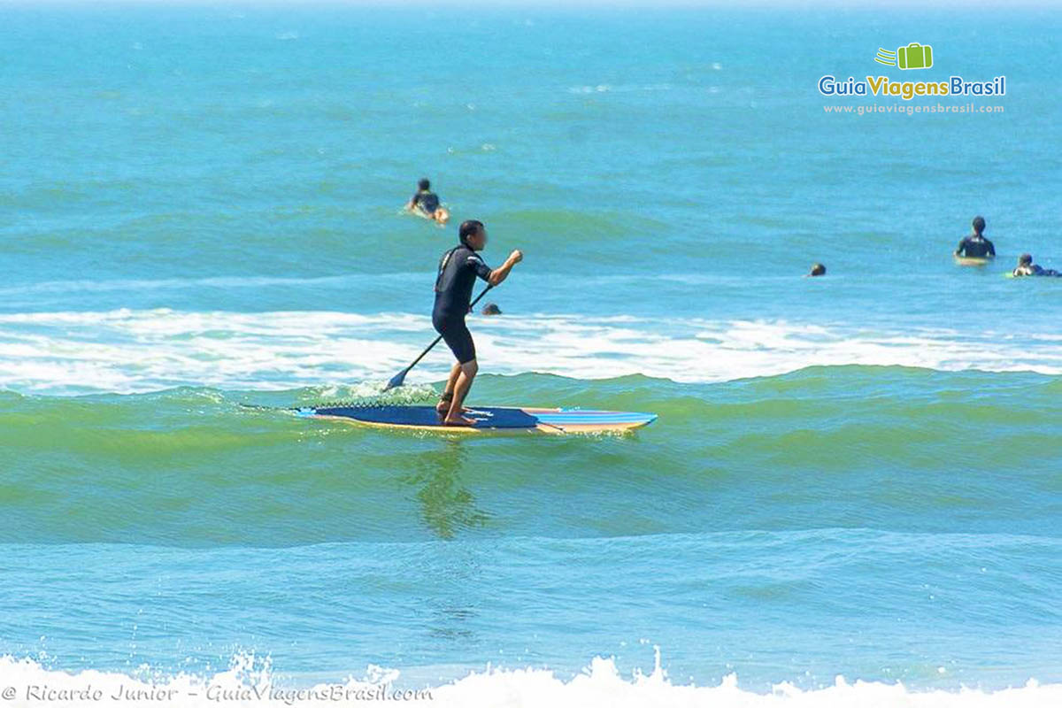 Imagem de uma pessoa praticando stand up paddle.