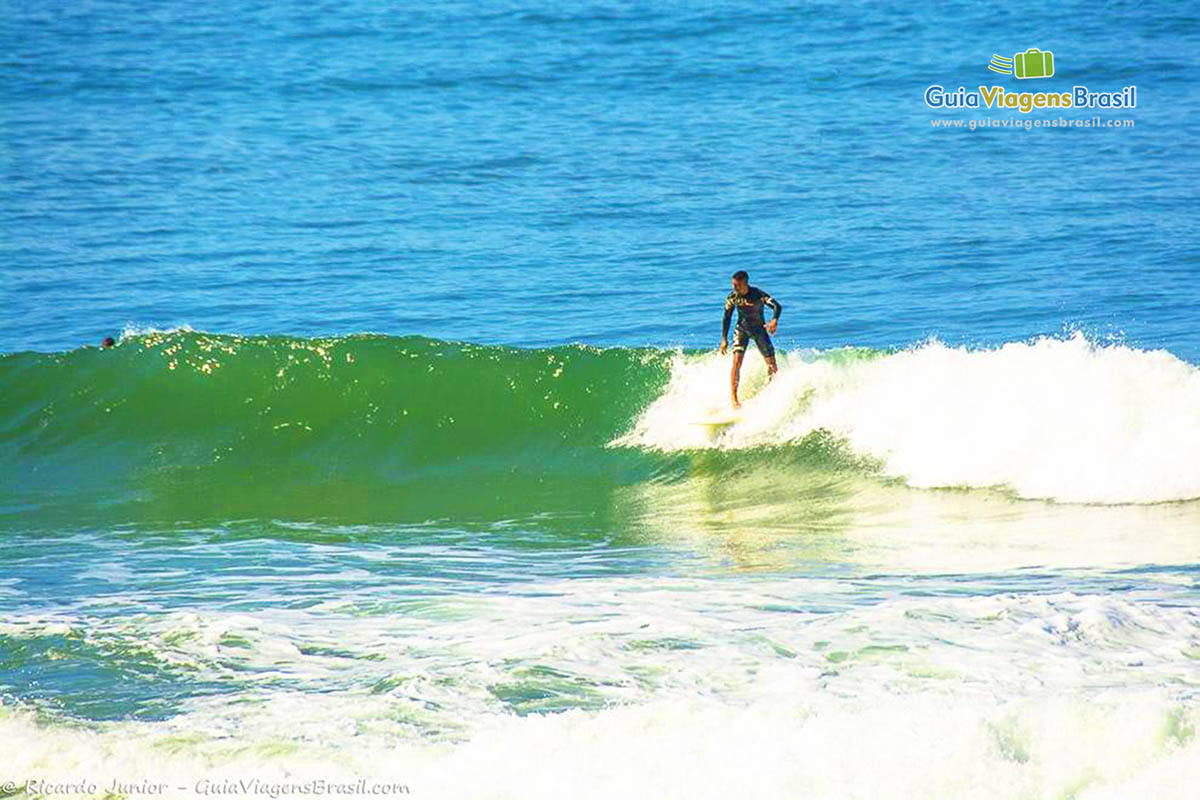 Imagem de surfista no pico da onda.
