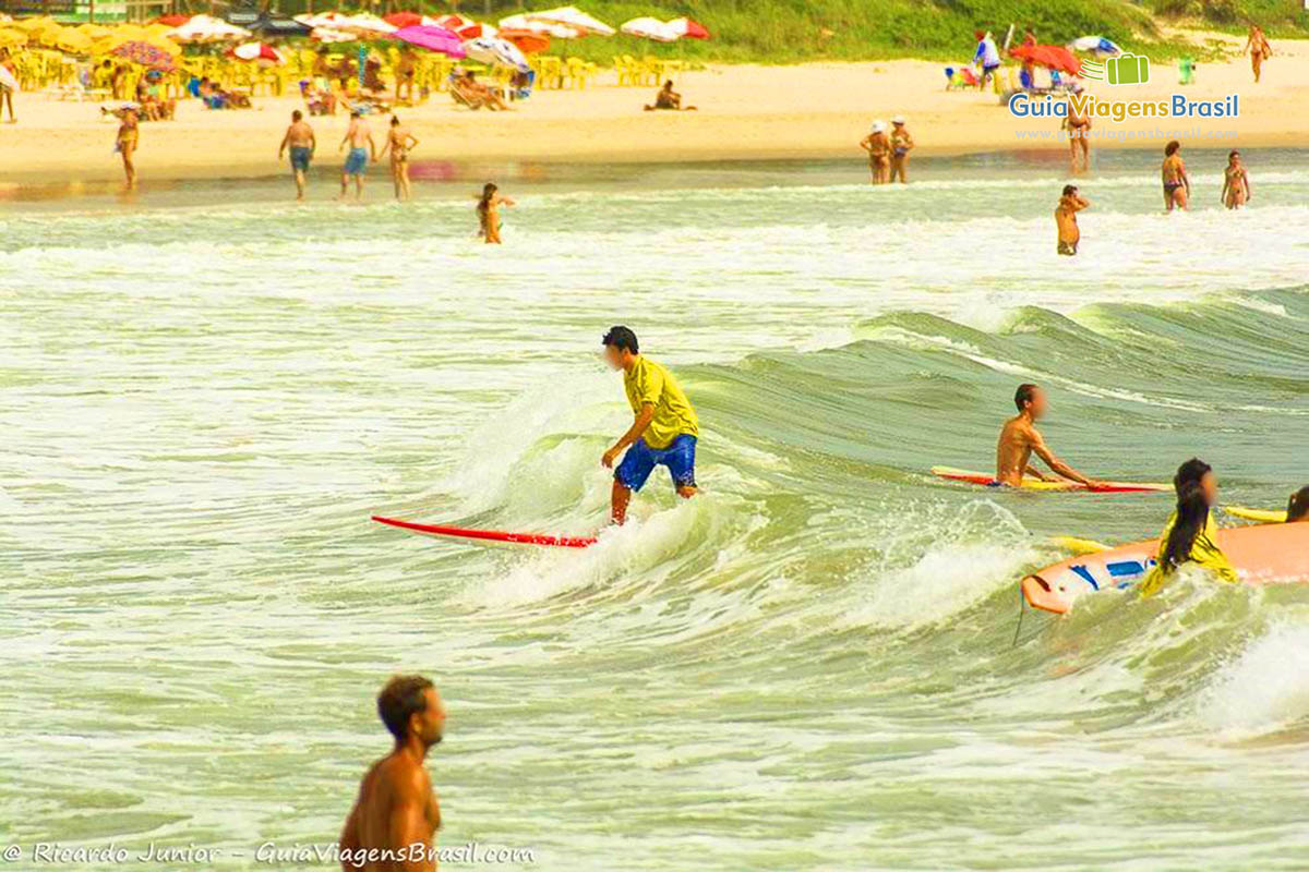 Imagem de menino surfando no raso pois esta aprendendo.