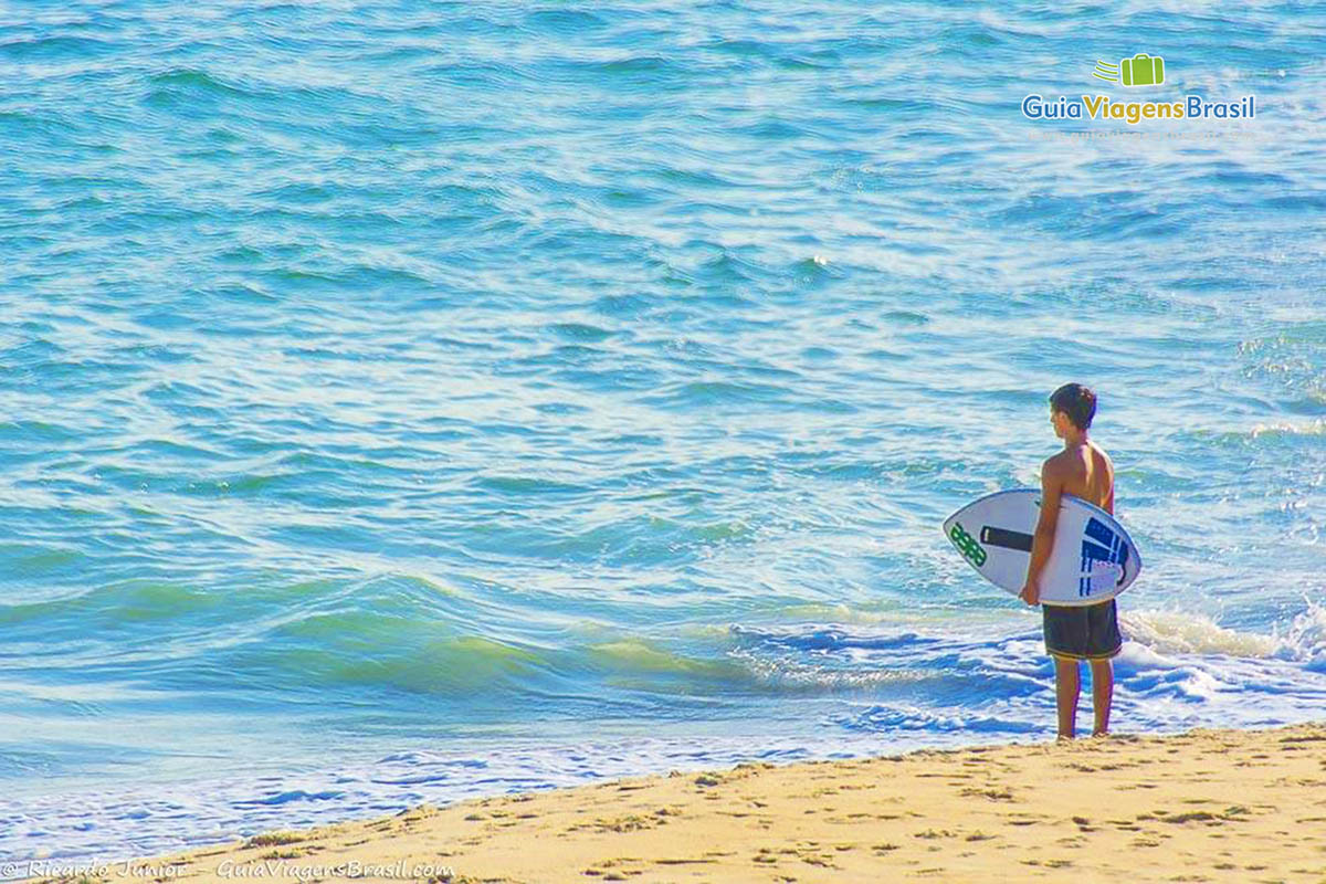 Imagem de um surfista admirando o mar da bela praia em São Sebastião.