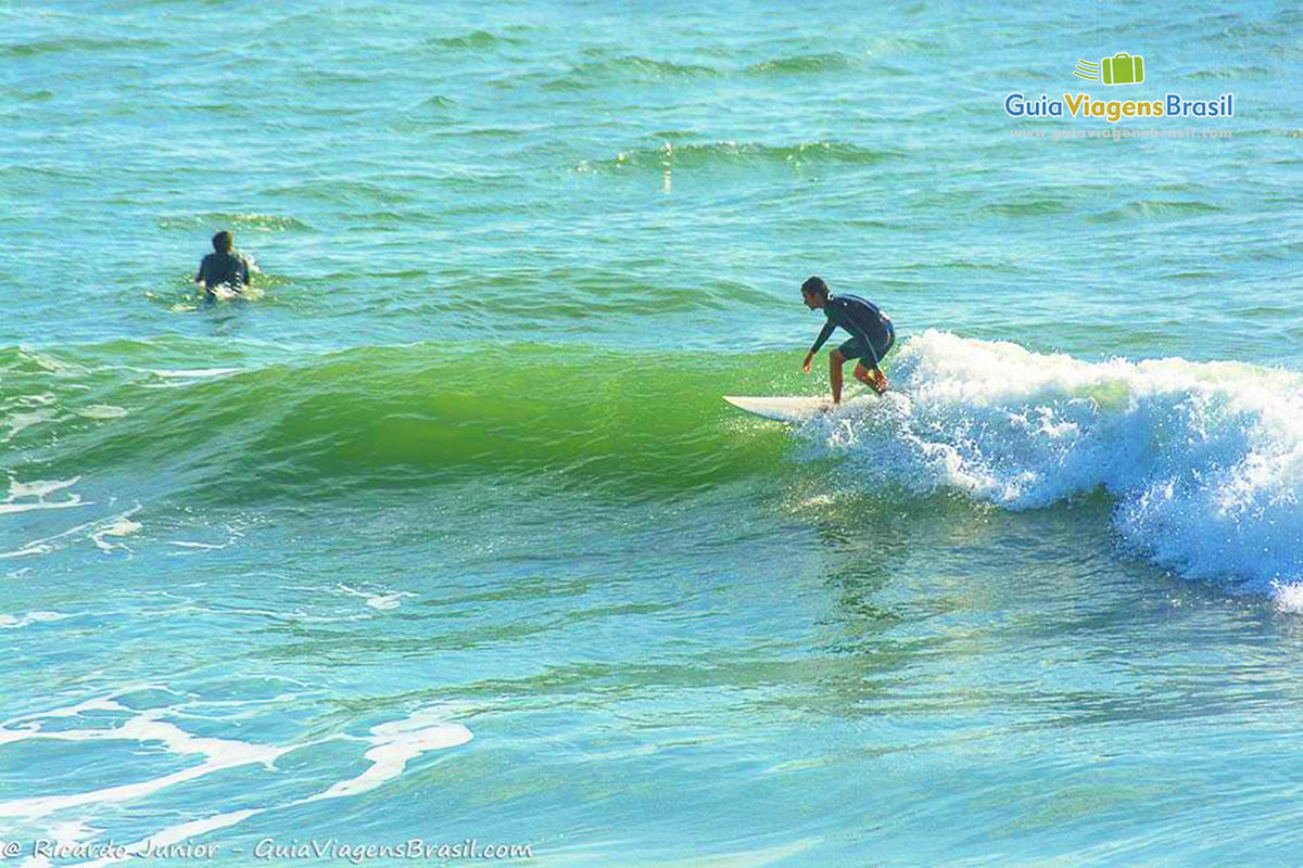Imagem de um surfista no mar da Praia do Rosa.