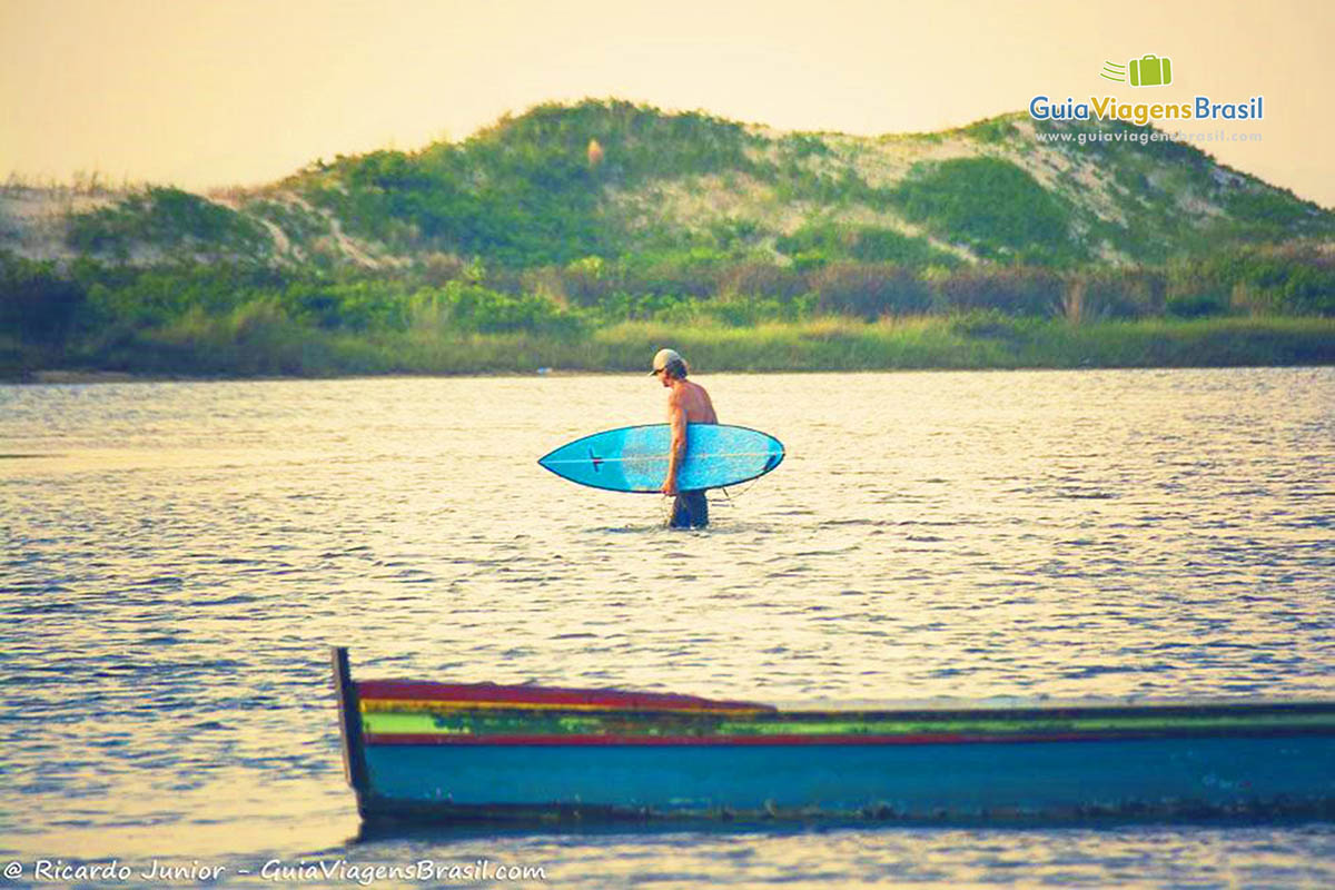 Imagem de surfista entrando no mar da Praia Guarda do Embaú.